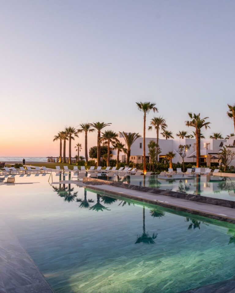 Blue swimming pools at Grecotel Creta Palace during sunset in Crete
