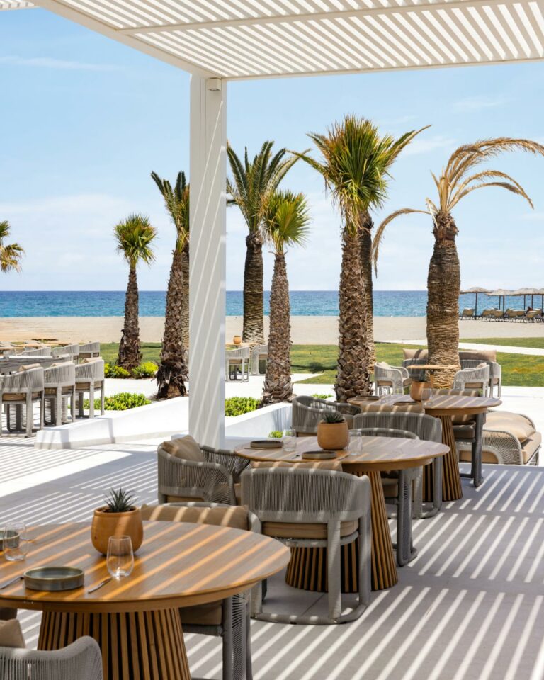 Seafront dining at Brasserie Ariadne with palm trees and sea views