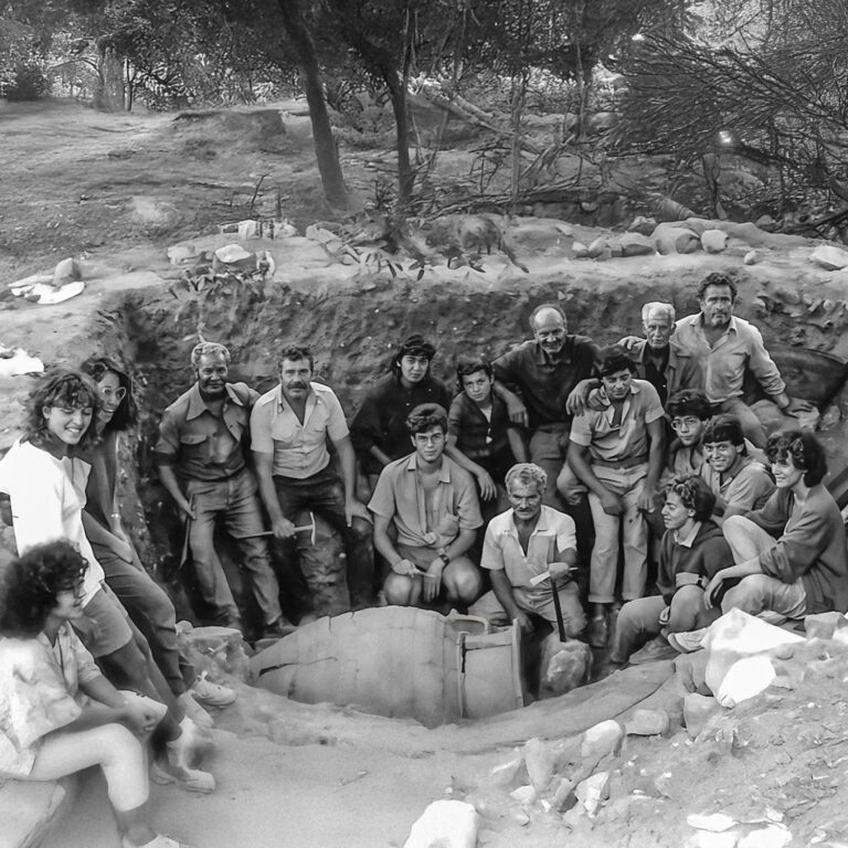 Group of archaeologists gathered around a circular structure at Eleutherna