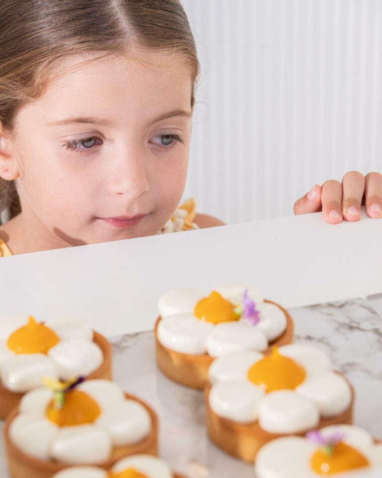 Child choosing decorated pastries at Grecotel Creta Palace Patisserie