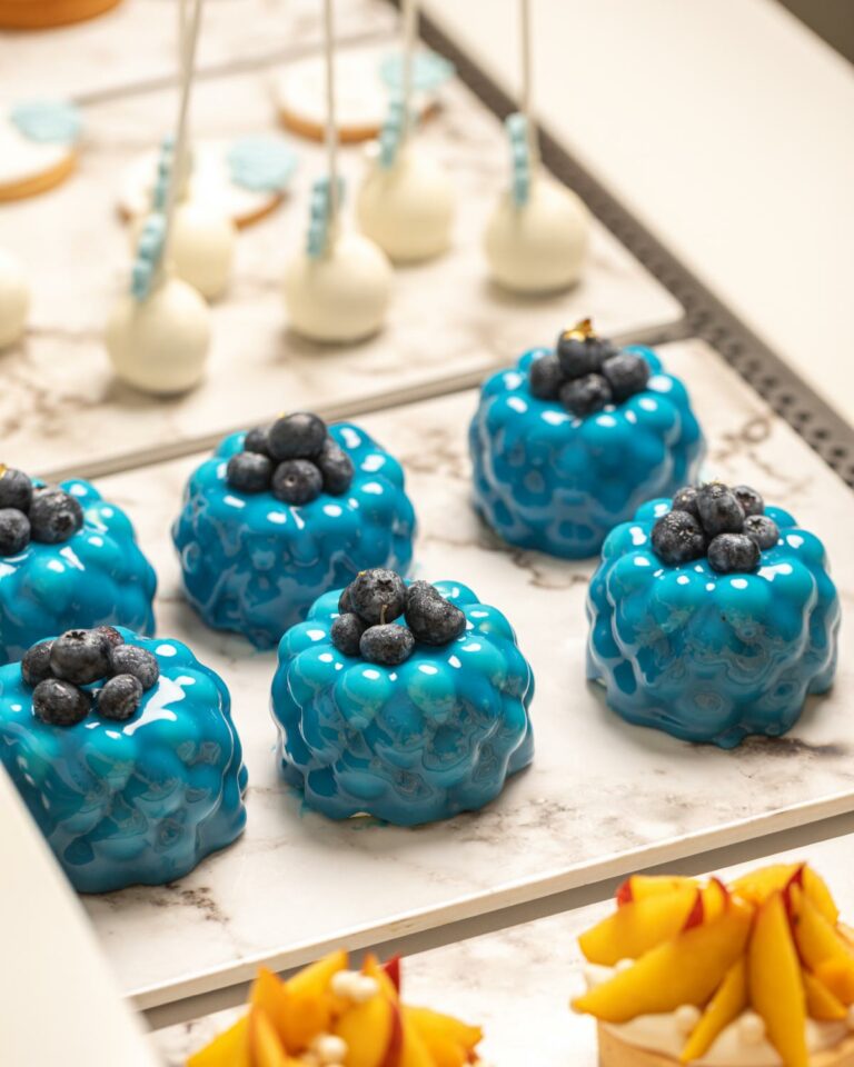 Blue glazed mini pastries topped with blueberries at Grecotel Creta Palace Patisserie
