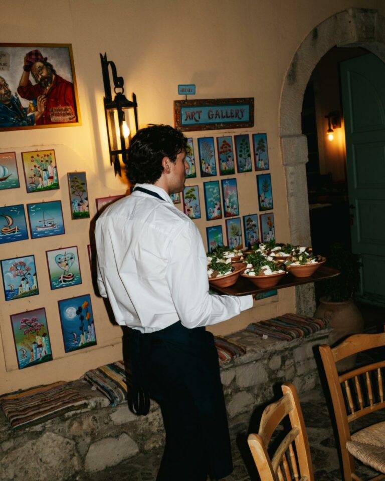 Waiter serving Cretan food inside Agreco Farm.