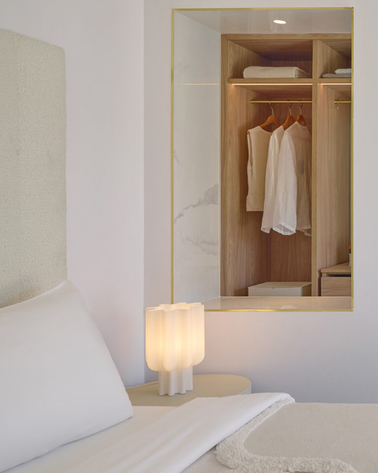 Bedroom detail with bedside lamp and open wardrobe in the Deluxe Room Panoramic at Filoxenia Kalamata