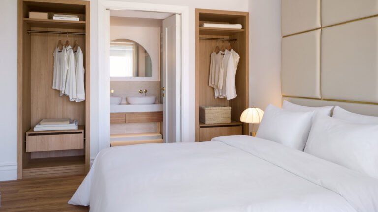 Deluxe Family Suite bedroom with open wardrobes and ensuite bathroom