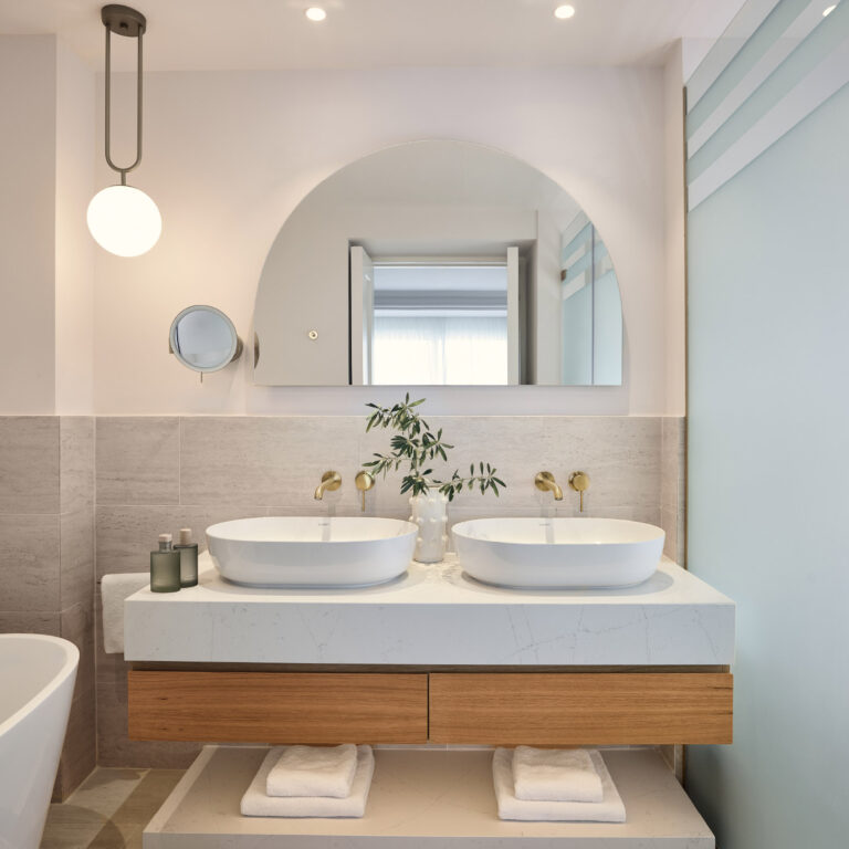 Bathroom with double vanity and arched mirror in the Two Bedroom Luxury Suite