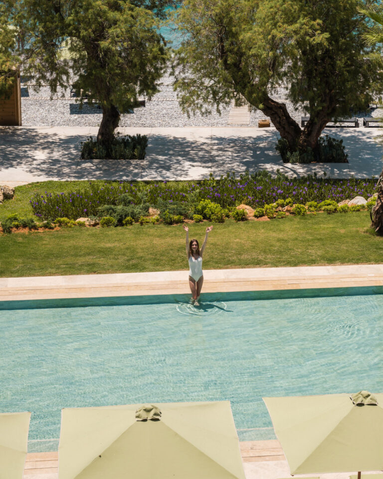 Woman swimming in the resort pool near the beachfront