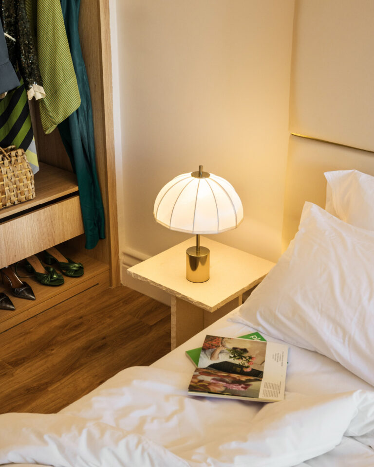 Bedside table, open wardrobe and bedroom details in the Two Bedroom Luxury Suite
