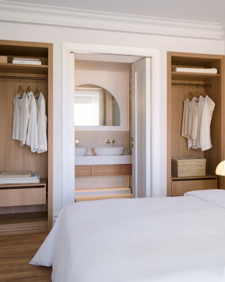 Bedroom with open wardrobes and bathroom access in the Two Bedroom Luxury Suite with Garden