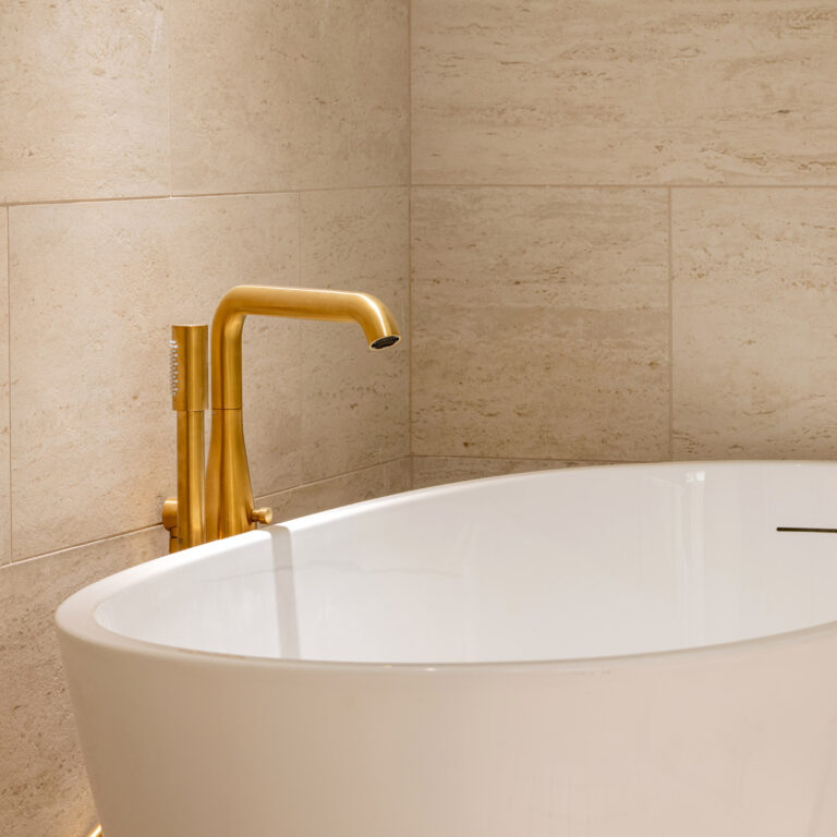 Bathtub with brass fixtures in the Deluxe Family Suite bathroom at Filoxenia Kalamata
