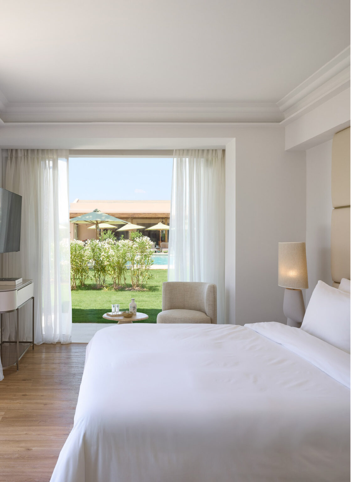 Deluxe Seafront Suite bedroom overlooking the palm gardens and pool