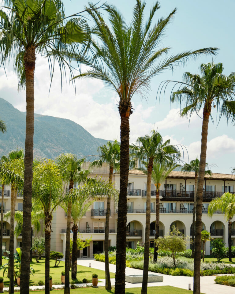 Grecotel Filoxenia Kalamata exterior surrounded by palm trees and gardens