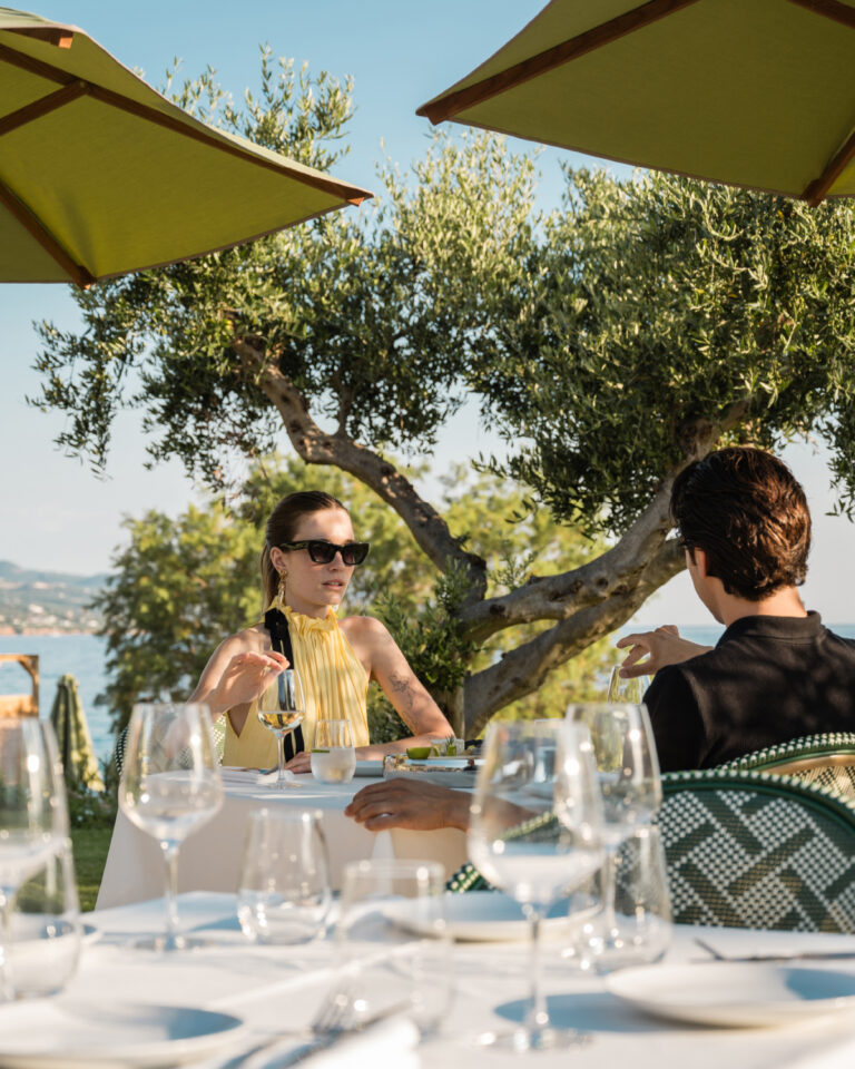 Couple dining outdoors with sea views at Grecotel Filoxenia Kalamata