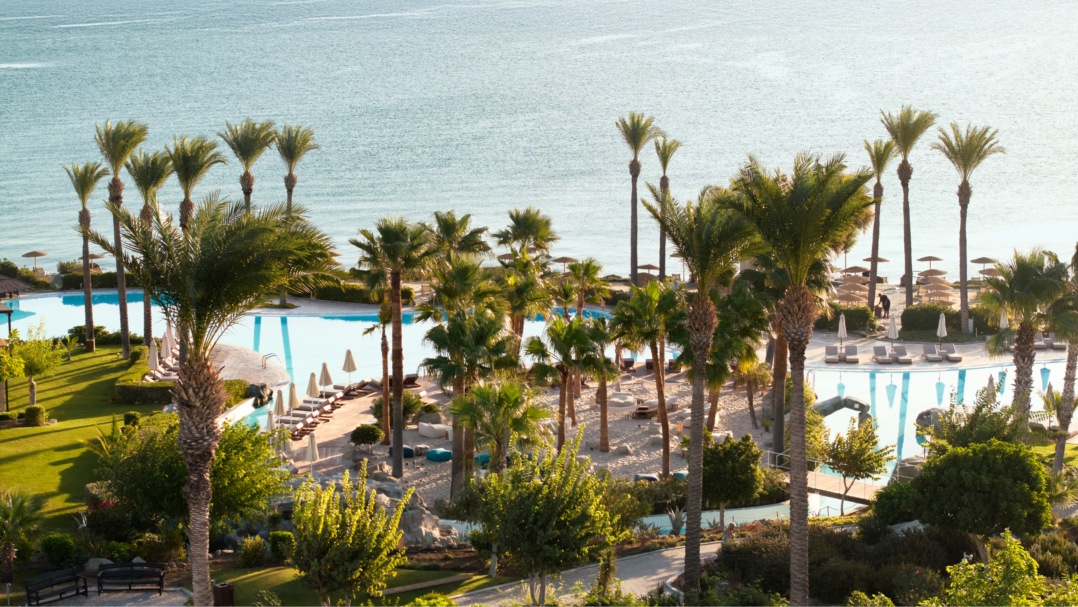Aerial view of LUXME Kos resort with pools, gardens, and beach