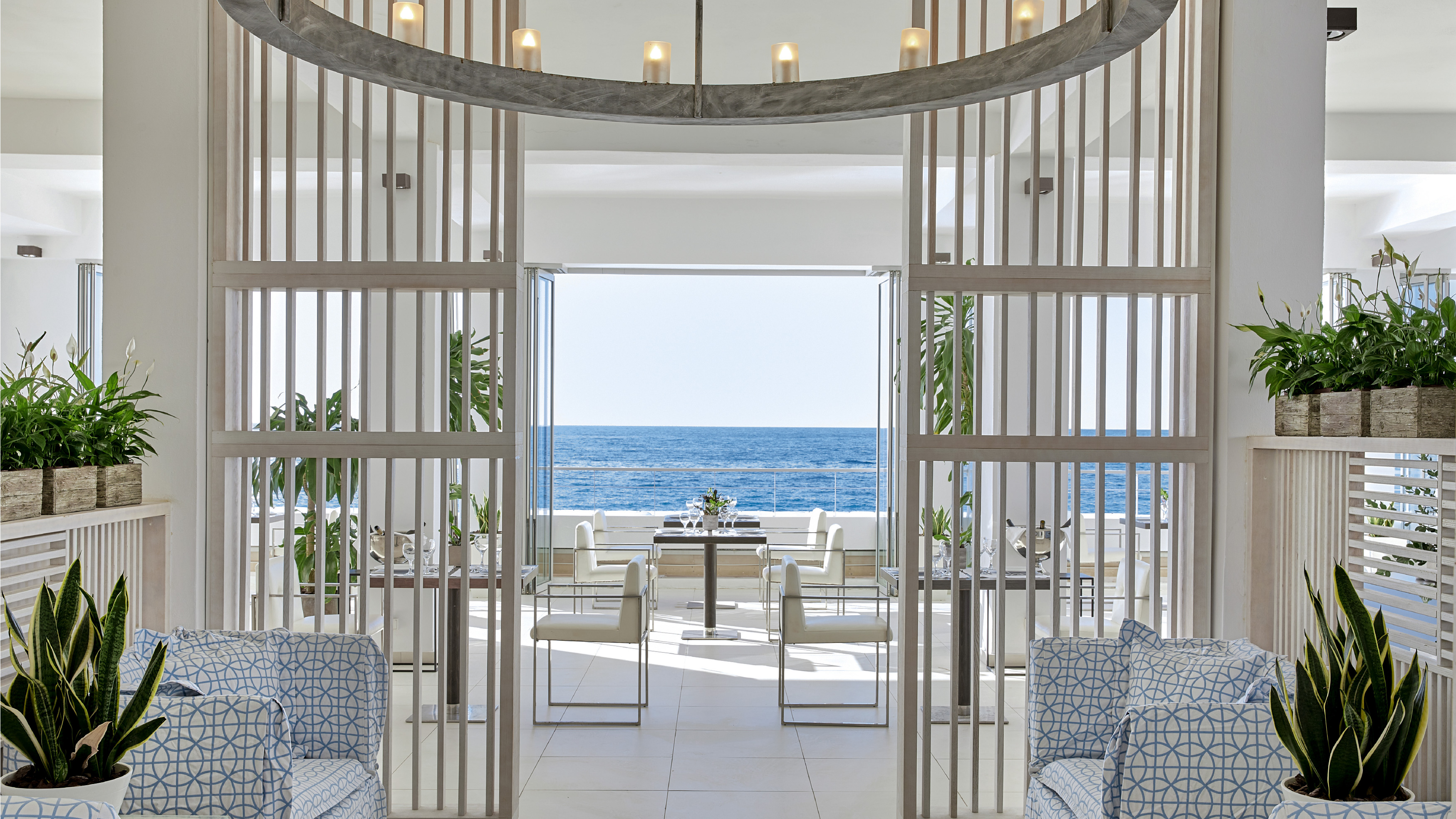 Grecotel LUXME White Crete Ventanas il Mar restaurant with sea view and outdoor seating.