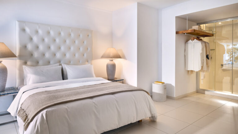 Grecotel LUXME White Crete White Family Suite bedroom with upholstered headboard and wardrobe.