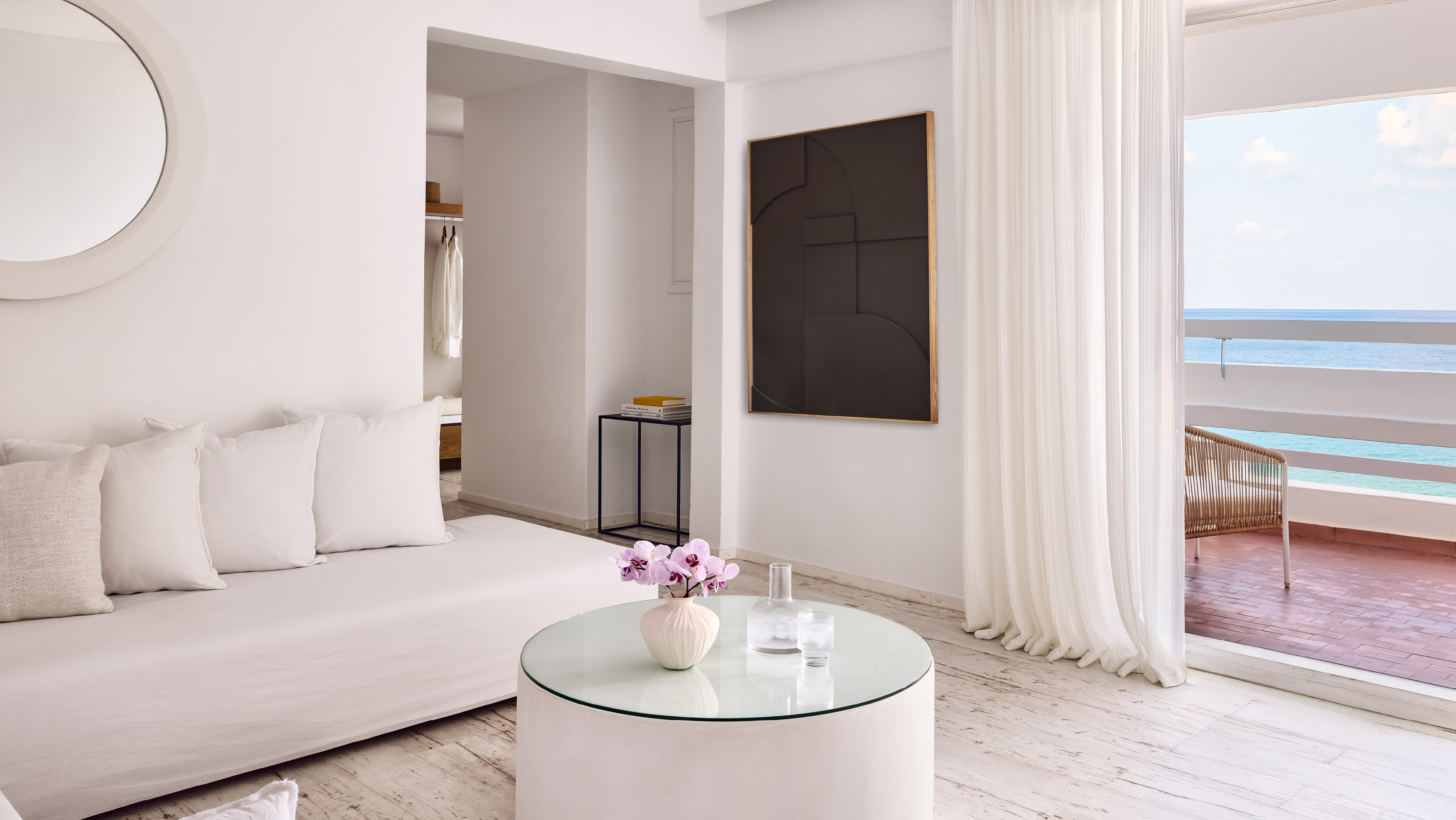 Grecotel LUXME White Crete Grand Family Suite living area with sofa, sea view and balcony.