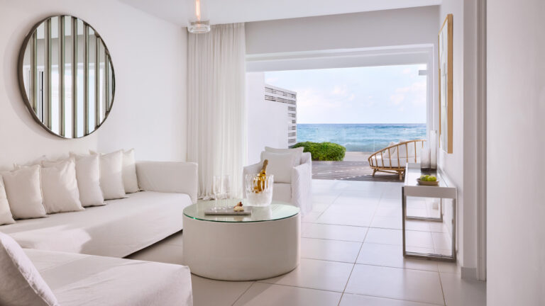 Grecotel LUXME White Crete Villa Luxe Yali living area with sofa and sea view.