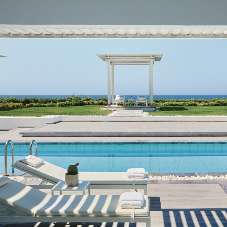 Grecotel LUXME White Crete swim-up pool with sunbeds, sea view and garden cabana.