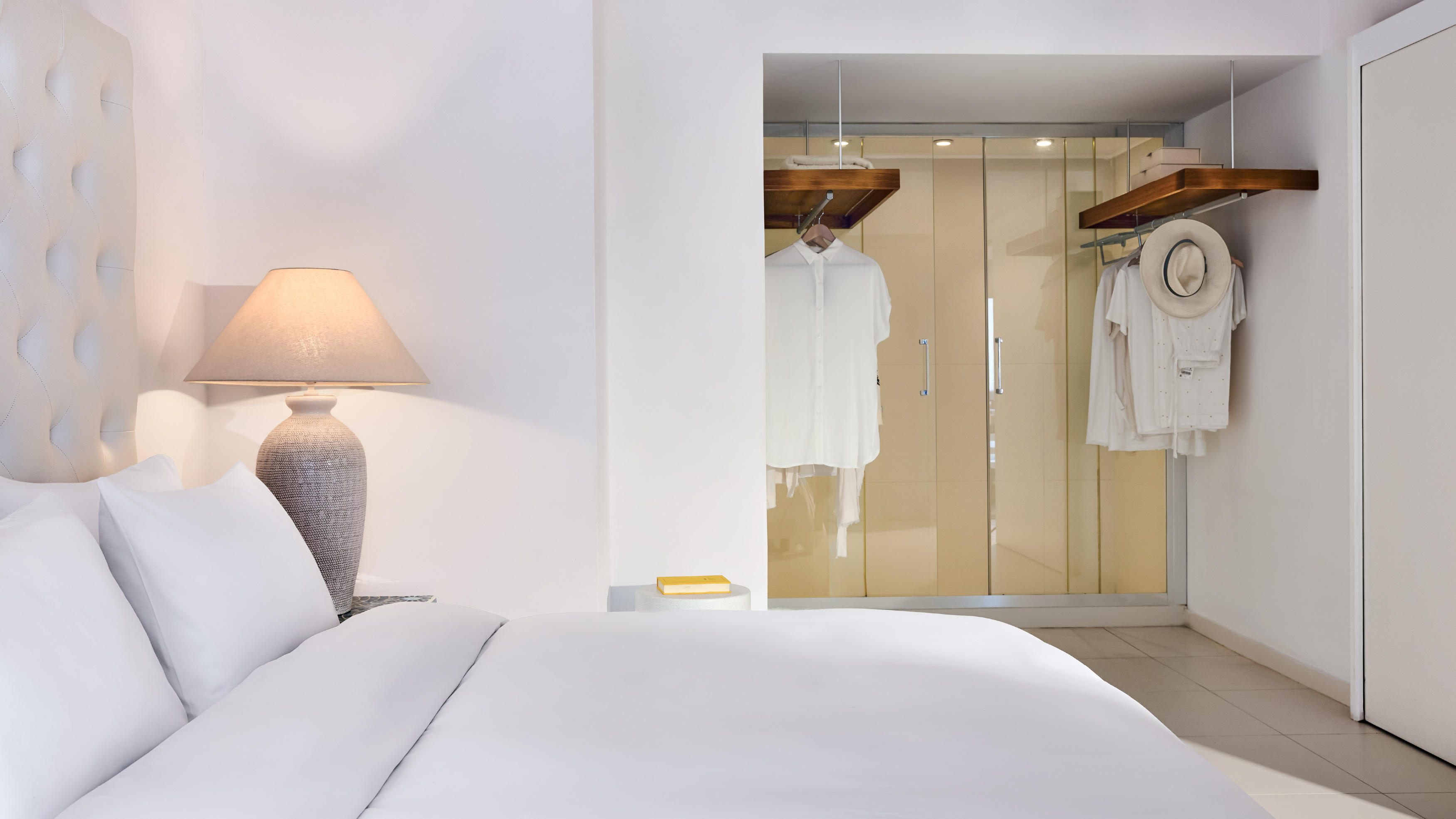 Grecotel LUXME White Crete White Suite bedroom with wardrobe and white bed.