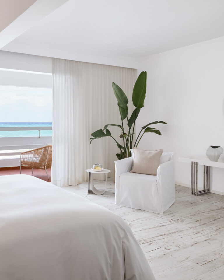 Grecotel LUXME White Crete Junior Suite bedroom and seating area with sea view.