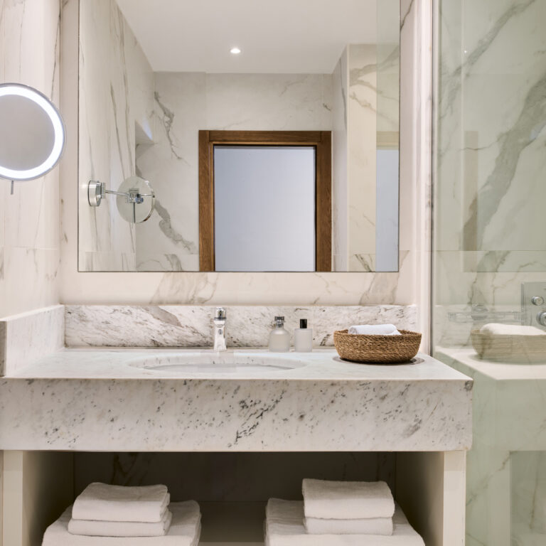 Grecotel LUXME White Crete Family Guestroom bathroom with marble vanity and shower.