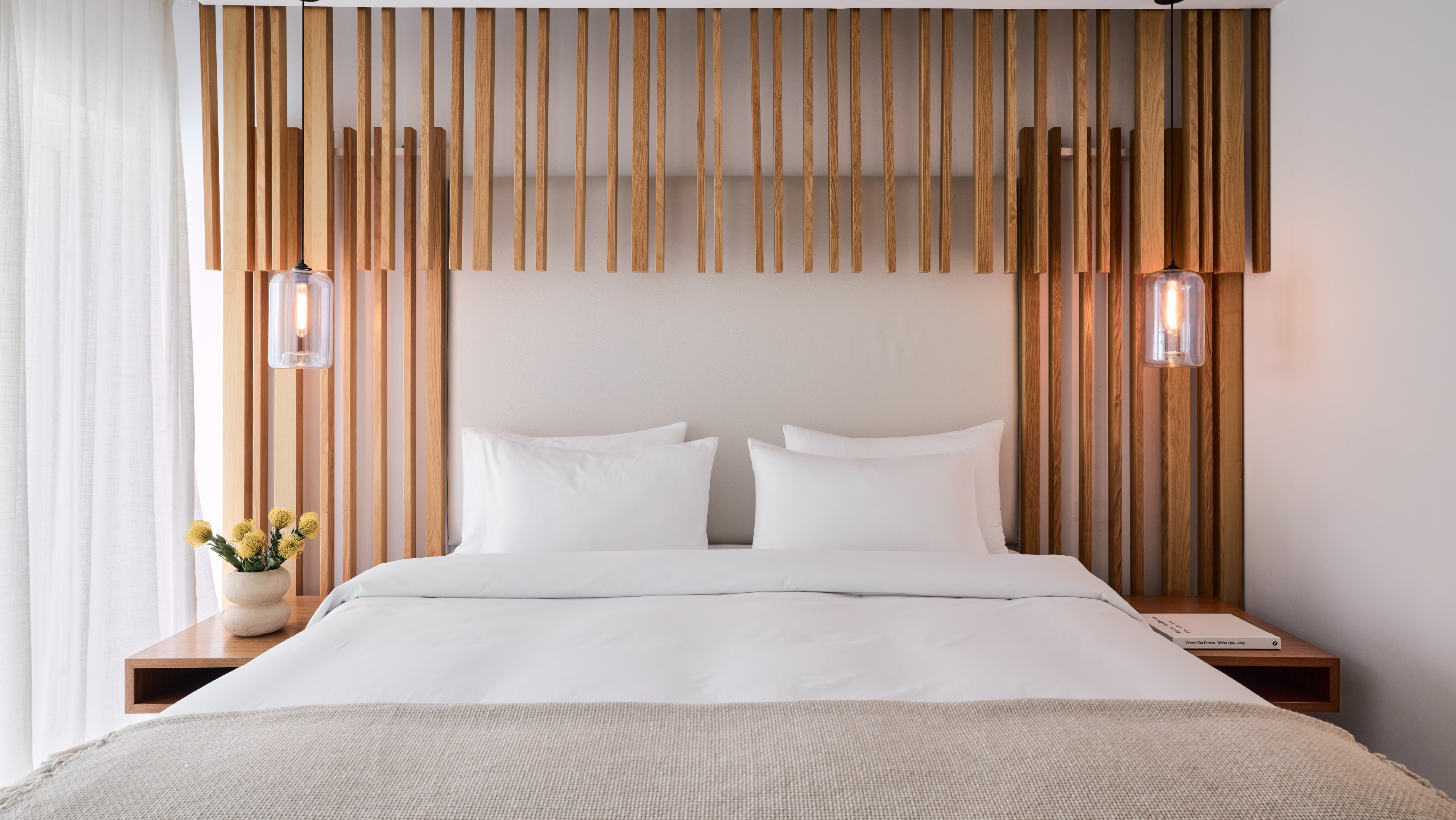 Grecotel LUXME White Crete Villa Luxe Yali bedroom with king bed and wooden headboard.