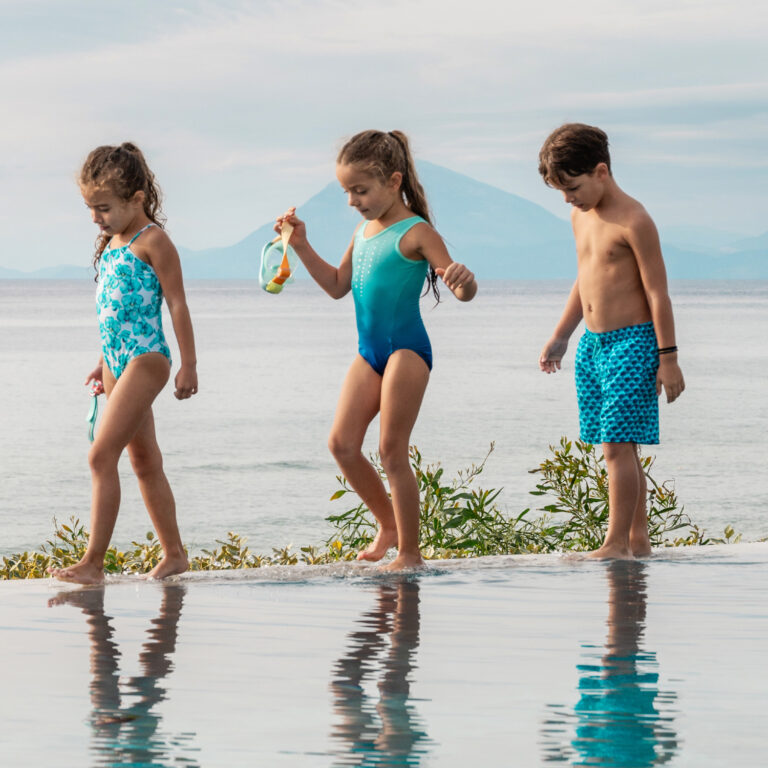 Children playing in the pool overlooking the sea at Grecotel LUXME White Crete.