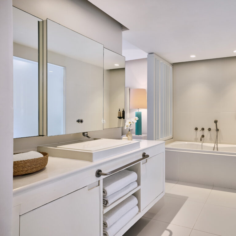 Grecotel LUXME White Crete Yali Seafront Suite bathroom with vanity, mirrors and bathtub.