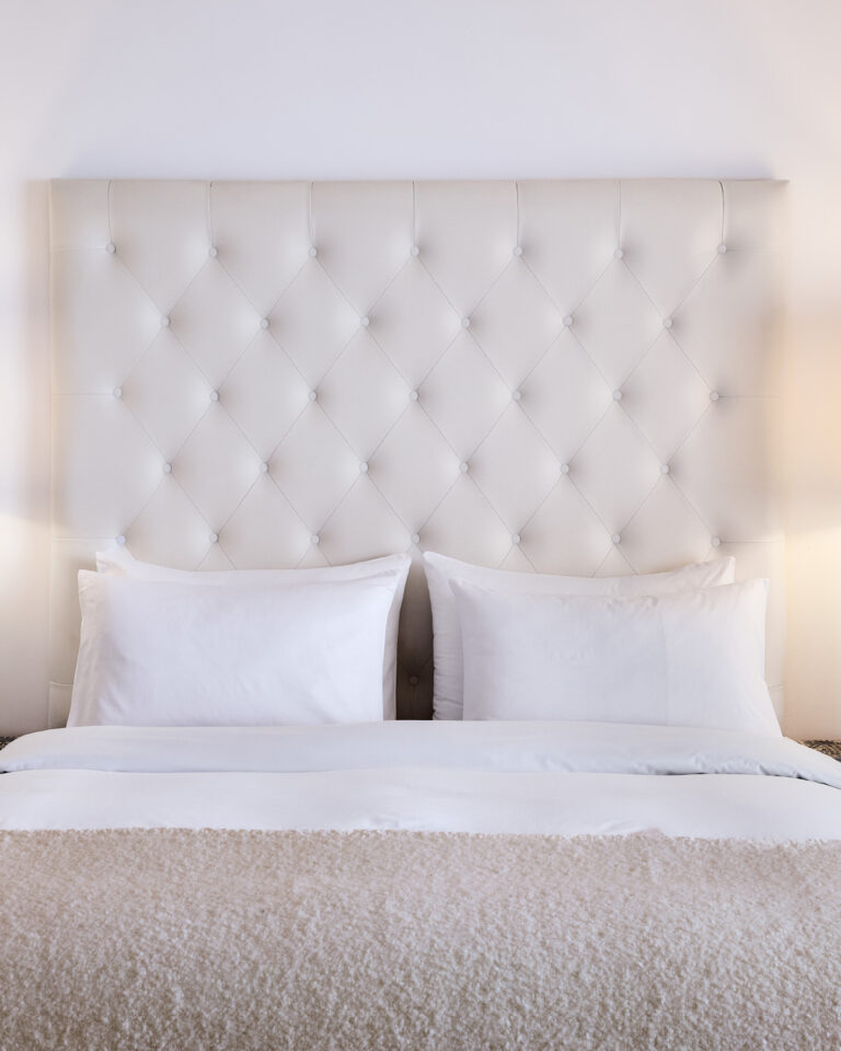 Grecotel LUXME White Crete Family Apartment king bed with upholstered headboard.