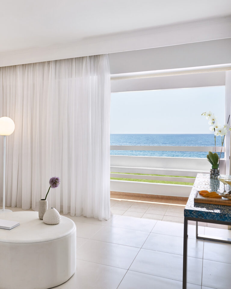 Grecotel LUXME White Crete White Family Suite living area with sea view and balcony.
