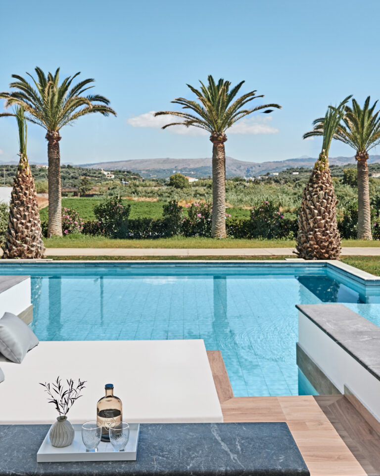 Grecotel LUXME White Crete Swim-up Family Guestroom pool with daybed, drinks and mountain view.