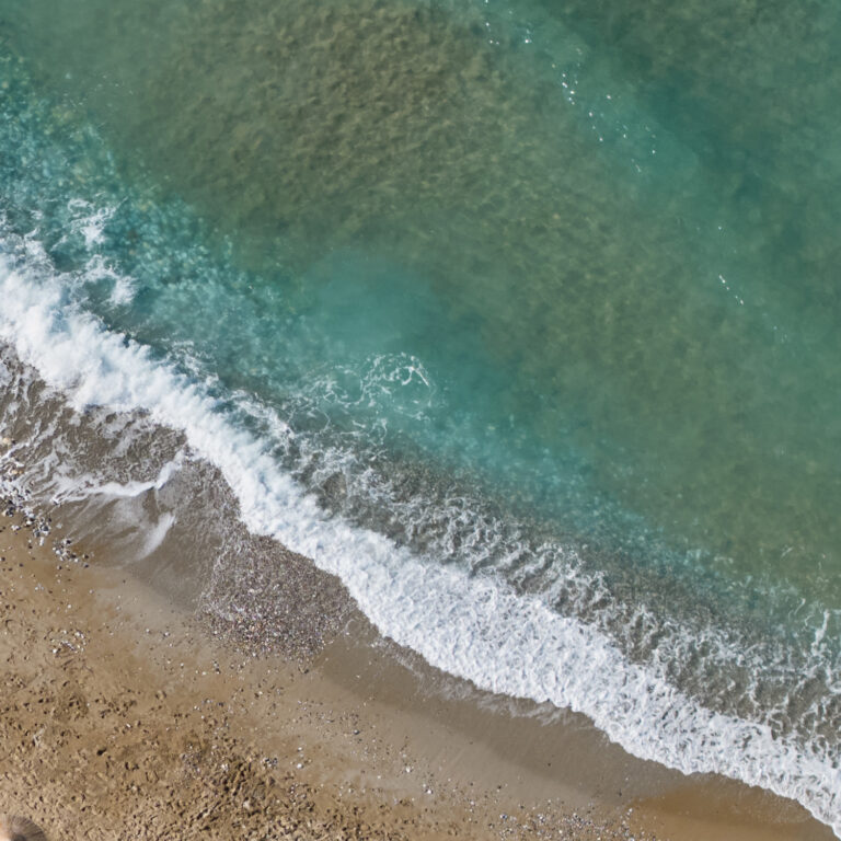 Grecotel LUXME White Crete beach and clear sea viewed from above.