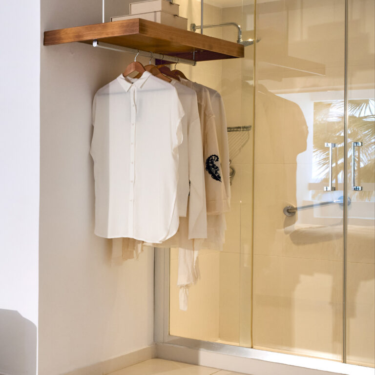Grecotel LUXME White Crete White Suite wardrobe and glass shower area.