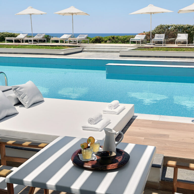 Grecotel LUXME White Crete swim-up pool with sunbed, sea view and refreshments.