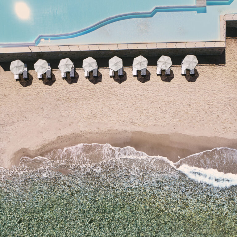 Aerial view of Grecotel LUXME White Crete pool, beach and sea.