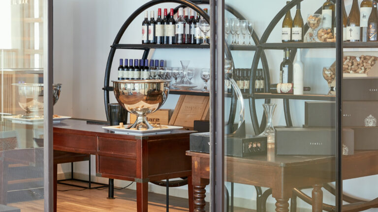 Wine bottles and glassware displayed in the Wine Library at Grecotel LUXME White Crete.