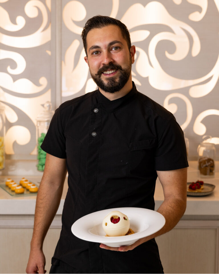 Chef presenting a dessert at Grecotel LUXME White Crete.