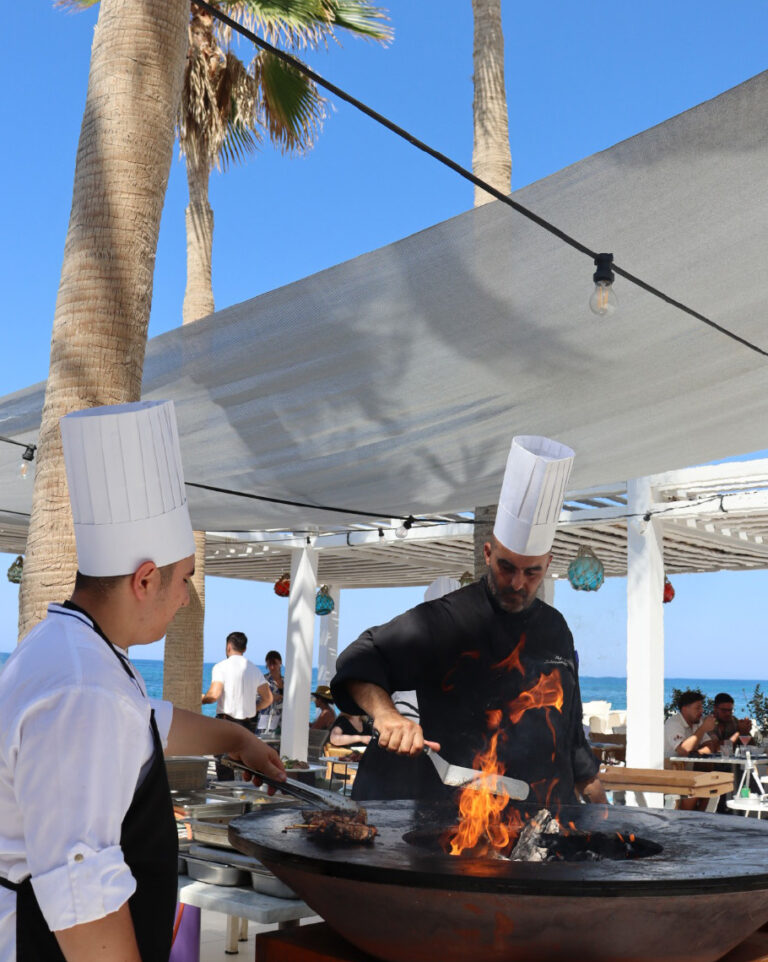 Chefs preparing barbecue dishes beside the beach at Grecotel LUXME White Crete.