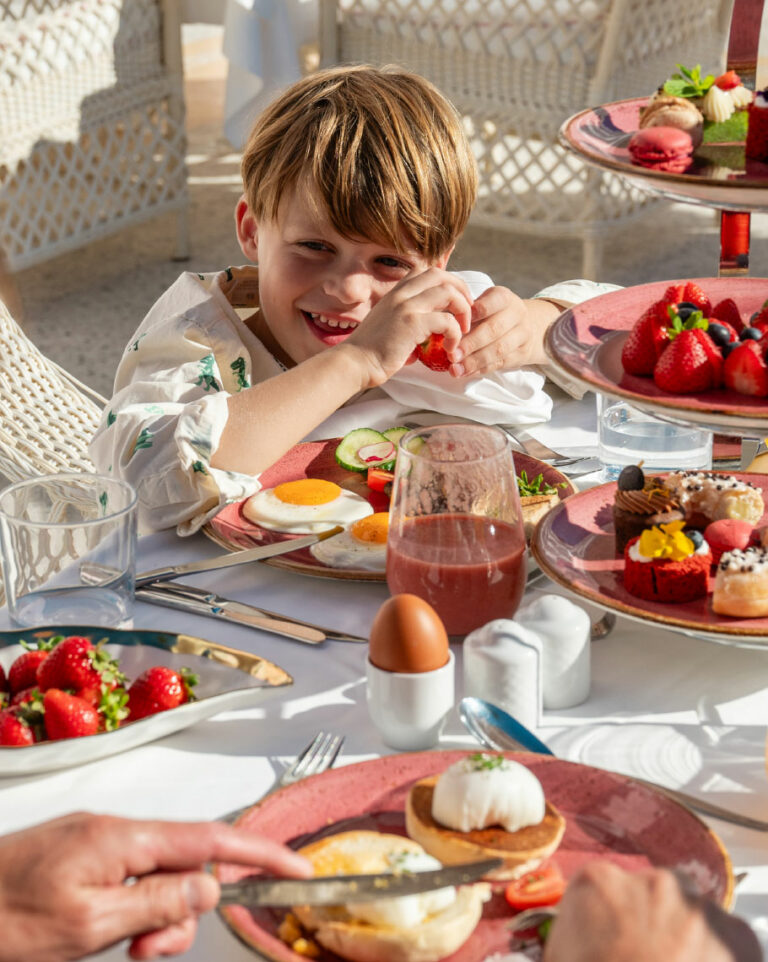 Child enjoying breakfast with fresh fruit and pastries at Grecotel LUXME White Crete.