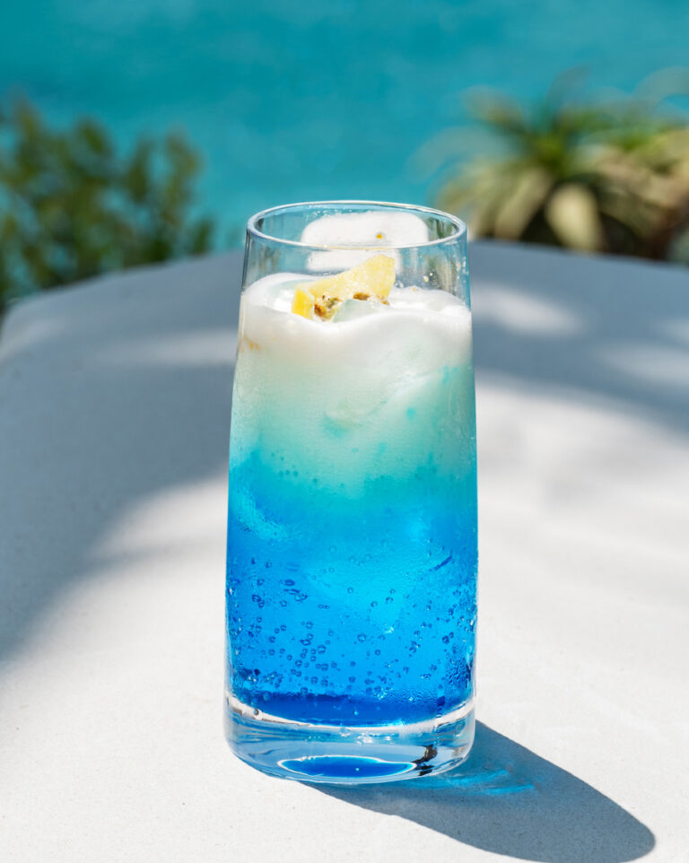 Blue cocktail with lemon garnish at Grecotel LUXME White.