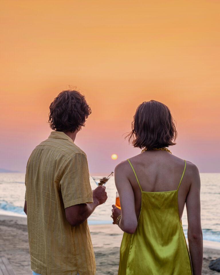 Couple enjoying cocktails overlooking the sea at sunset at Grecotel LUXME White.